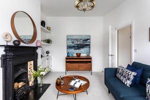 a living room with a blue couch and a mirror at Gorgeous Clapham Flat in London