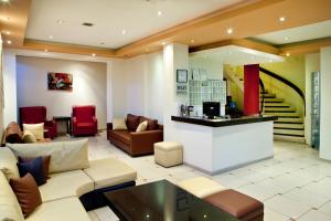 a lobby with a couch and chairs and a staircase at CiTYZen Hotel in Loutraki