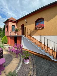 a house with a purple bench and a staircase at Sebe apartments 1 in Holíč