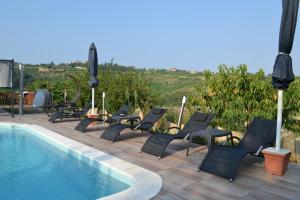 een rij stoelen naast een zwembad bij Agriturismo San Martino in Castiglione Tinella