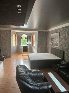 a bedroom with a bed and a leather couch at Sebe apartments 1 in Holíč