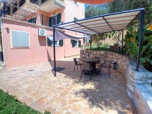 a patio with a table and chairs and an umbrella at Marianna's room in Virós