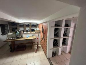 a room with a desk and a wall of wine bottles at Sebe apartments 1 in Holíč