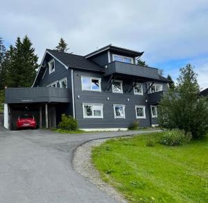 ein großes Haus mit einem Auto in der Einfahrt in der Unterkunft Sentral 4-roms leilighet i Trollbakken in Tromsø
