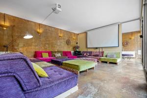 a living room with purple couches and a projection screen at Villa Lux Ana in L'Ametlla de Mar