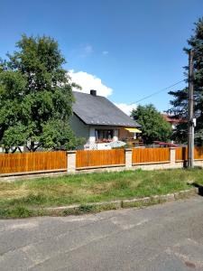 a house with a fence next to a road at Penzion u krbu in Loket