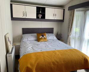 um quarto com uma cama com um cobertor amarelo em Honeycomb Lodge em Dollar