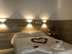 Un dormitorio con una cama con una decoración de corazón. en Pousada Melendez, en Búzios