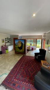 ein Wohnzimmer mit einem Sofa und einem Großbild-TV in der Unterkunft Hidden Gem Art Guesthouse , one of a kind in Germiston