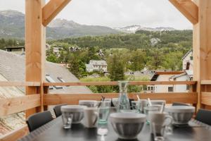 una mesa en un balcón con vistas a las montañas en Chaleureux appartement 8 couchages #4 en Embrun