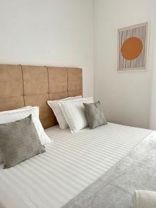 ein großes Bett mit weißer Bettwäsche und Kissen in der Unterkunft Aurus 2 in Korčula