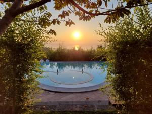 una piscina con puesta de sol en el fondo en Etna Sunshine Rent Rooms, en Puntalazzo