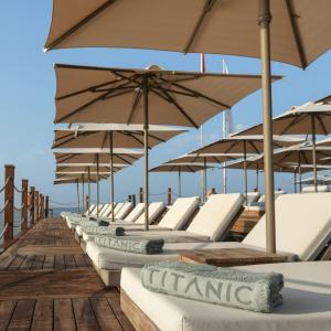 a row of lounge chairs and umbrellas on a boat at Titanic Deluxe Golf Belek in Belek