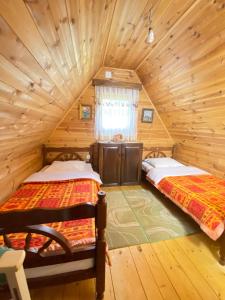 dwa łóżka w pokoju w drewnianym domku w obiekcie Vikendica Verusa w mieście Veruša