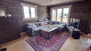 ein Wohnzimmer mit einem Sofa und einem Tisch in der Unterkunft Ny tømmerhytte in Tveiten