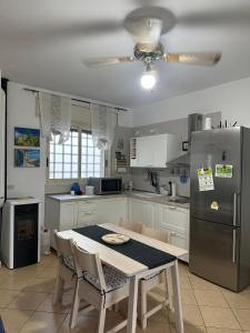 a kitchen with a table and a stainless steel refrigerator at Casa Vacanze Lisa in Torre Ovo