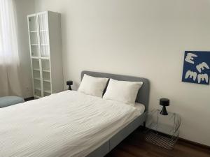 a bedroom with a large bed with white sheets at Spacious apartment near the city centre in Bratislava