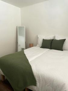 a bedroom with a large white bed with green pillows at Spacious apartment near the city centre in Bratislava