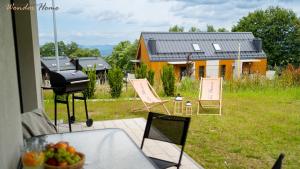 a table with a bowl of fruit and a grill on a house at Wonder Home - Domki Hillside tuż przy stoku narciarskim - na terenie kompleksu plac zabaw i zewnętrzna siłownia, sklep, parking in Karpacz +233 photos