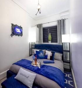 a bedroom with a blue bed with a blue blanket at Swanky Seaside Sanctuary w/ foozeball - Southend in Southend-on-Sea