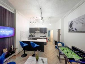 a living room with a kitchen and a dining room at Swanky Seaside Sanctuary w/ foozeball - Southend in Southend-on-Sea