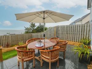 a table and chairs with an umbrella on a patio at Tŷ Glas in Bridgend