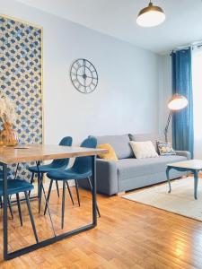 a living room with a couch and a table and chairs at Sweet Cēmoi Retreat au calme, proche gare, Netflix in Grenoble