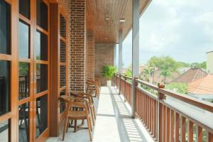 a balcony with chairs and tables on a building at Santera Village in Canggu