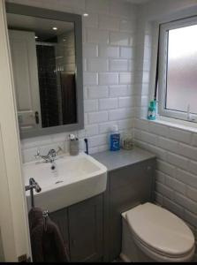 a bathroom with a sink and a toilet and a mirror at Charming 5 Bed - Leytonstone E11 in London