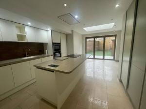 a kitchen with a island in the middle of a room at Charming 5 Bed - Leytonstone E11 in London