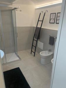 uma casa de banho com uma escada ao lado de um WC e um chuveiro em Loft Marconi 34 em Soverato Marina