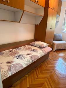 Bett in einem Zimmer mit Holzboden in der Unterkunft Viktor apartment in Kumanovo