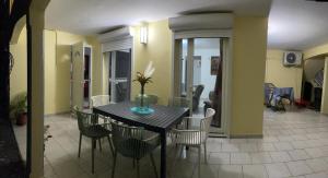 a dining table and chairs in a living room at Dyna 2 bedroom house in Sainte-Rose