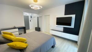 a bedroom with a bed and a tv on a wall at Lori`s Place in Piteşti