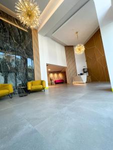 a lobby with yellow chairs and a stone wall at Lori`s Place in Piteşti