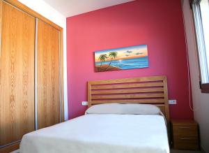 ein Schlafzimmer mit einem Bett und einer rosa Wand in der Unterkunft Hotur Via Augusta in Creixell + 22 Fotos