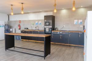 a large kitchen with blue cabinets and a counter top at Ocean Nomads Coworking in Arona