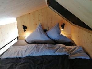a bed with two pillows on it in a room at Tiny House 2 im Allgäu mit gr. Garten, Randlage in Bad Wurzach