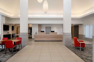 a lobby with red chairs and a waiting room at Hilton Garden Inn Folsom in Folsom