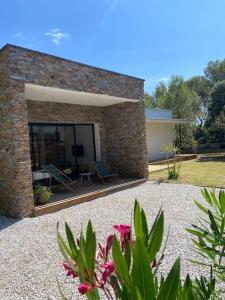 a brick building with a patio with a table and chairs at Maison proche du pic Saint Loup in Saint-Jean-de-Cuculles
