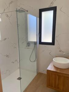 y baño con ducha acristalada y lavamanos. en Maison proche du pic Saint Loup en Saint-Jean-de-Cuculles