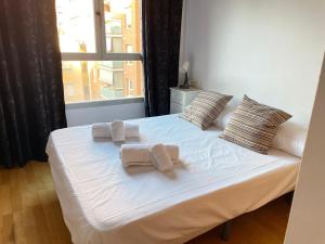 1 cama con 2 toallas y ventana en NEW! Amazing 2 bedroom apartment in Rambla del Poblenou, en Barcelona