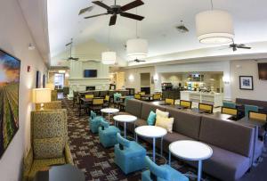 a lobby of a hotel with tables and chairs at Homewood Suites by Hilton Decatur-Forsyth in Forsyth