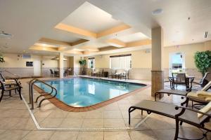a pool in a hotel lobby with tables and chairs at Homewood Suites by Hilton Decatur-Forsyth in Forsyth