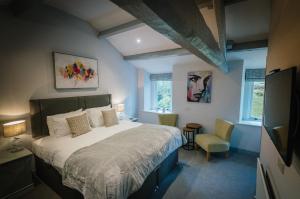 a bedroom with a large bed and a chair at Greta House in Keswick