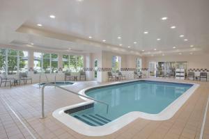 una piscina en una habitación grande con mesas y sillas en Hilton Garden Inn Springfield, MA en Springfield