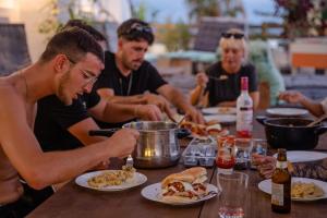 a group of people sitting at a table eating food at Ocean Nomads Coworking in Arona