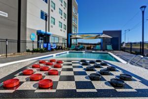 a chess board on a sidewalk next to a swimming pool at Tru By Hilton Tahlequah, Ok in Tahlequah