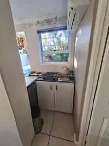 a small kitchen with a sink and a window at Sandpiper Self Catering in East London