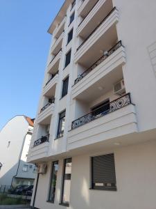 a tall white building with balconies on it at Apartment Mb lux 2 in Bijeljina